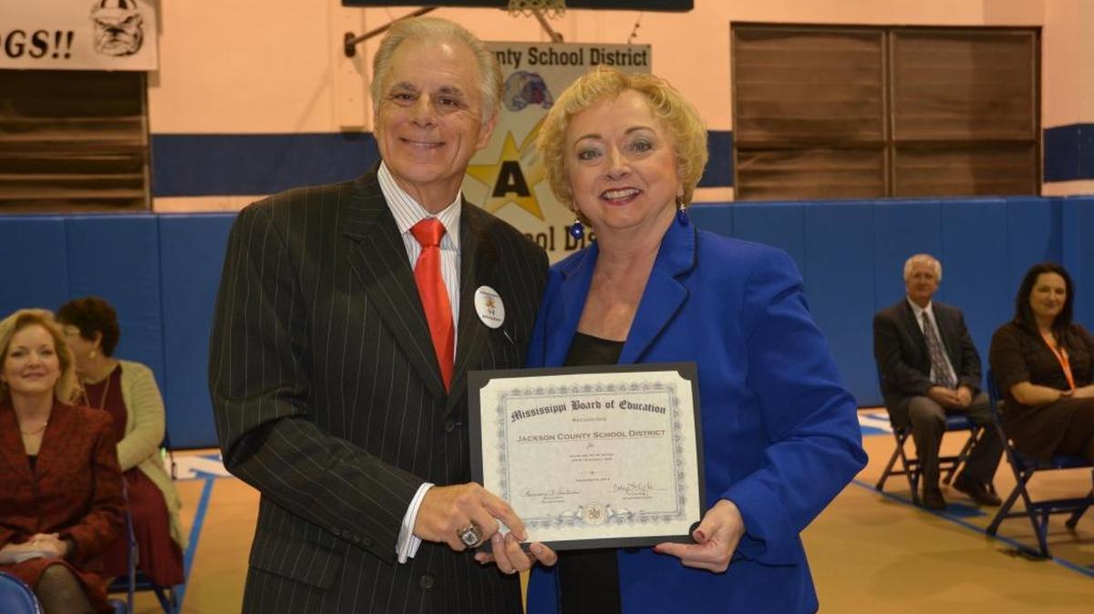 Jackson County School District Superintendent Barry Amacker stands next to Mississippi Department of Education Superintendent Carey Wright after receiving recognition for his work in elevating the school district from a B to an A grade this year.