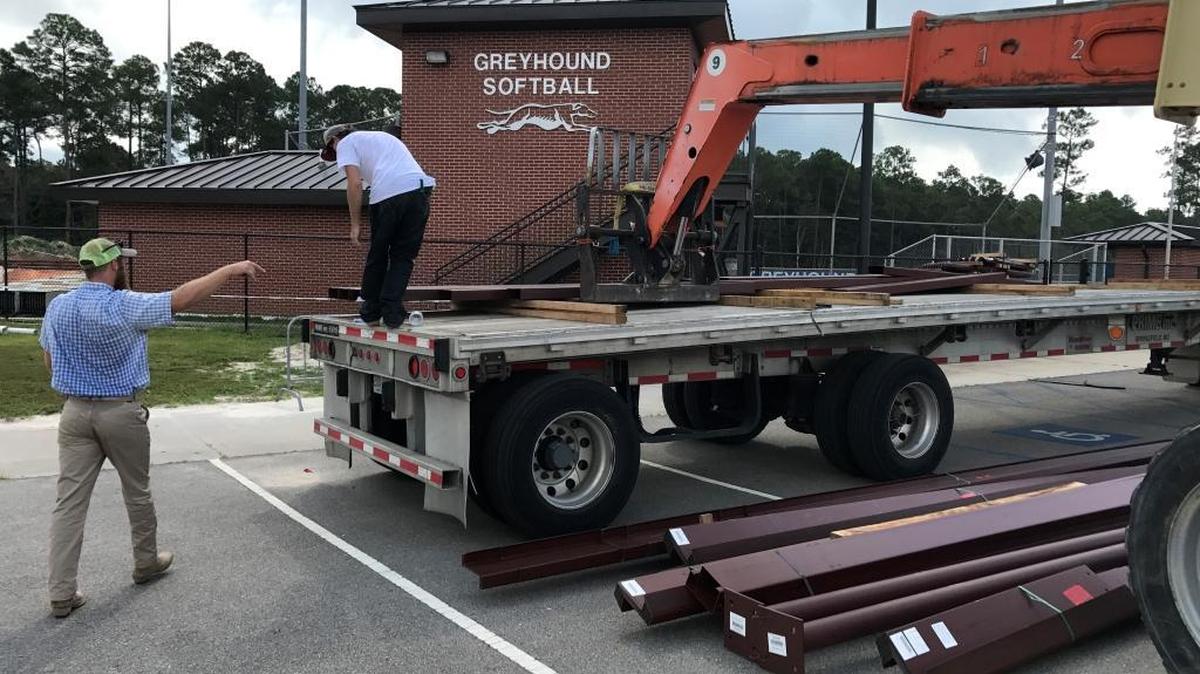 Workers unload material for softball practice facility under construction at Ocean Springs high school on Wednesday. The $524,000 facility will have locker rooms and batting cages.