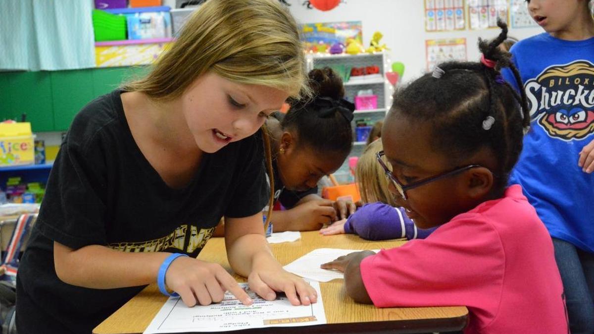 Alexis Zorich, 9, signs a friendship pledge with 6-year-old Taylor Richburg as part of a week of anti-bullying exercises for students at North Bay Elementary School.
