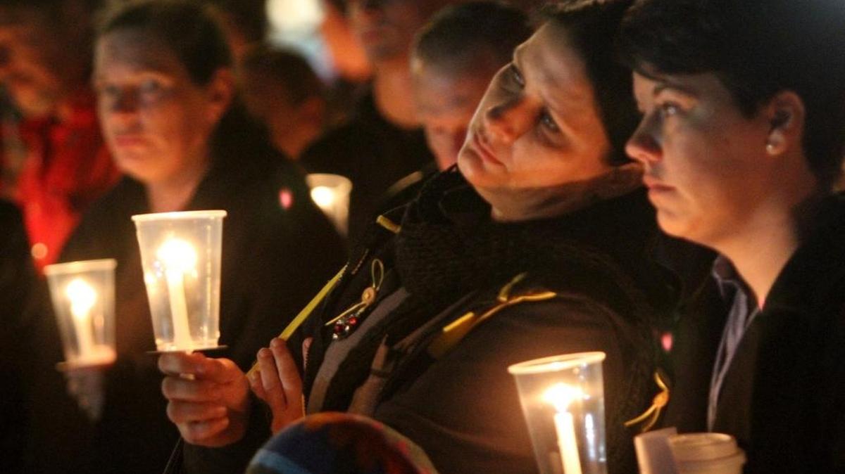Waffle House employees Kristie Bergeron of Ocean Springs, left, and Ashley Shaul of St. Martin hold candles in memory of their slain co-worker, Waffle House server Julie Brightwell, during a memorial service for her on the beach in Biloxi on Friday Dec. 4, 2015.