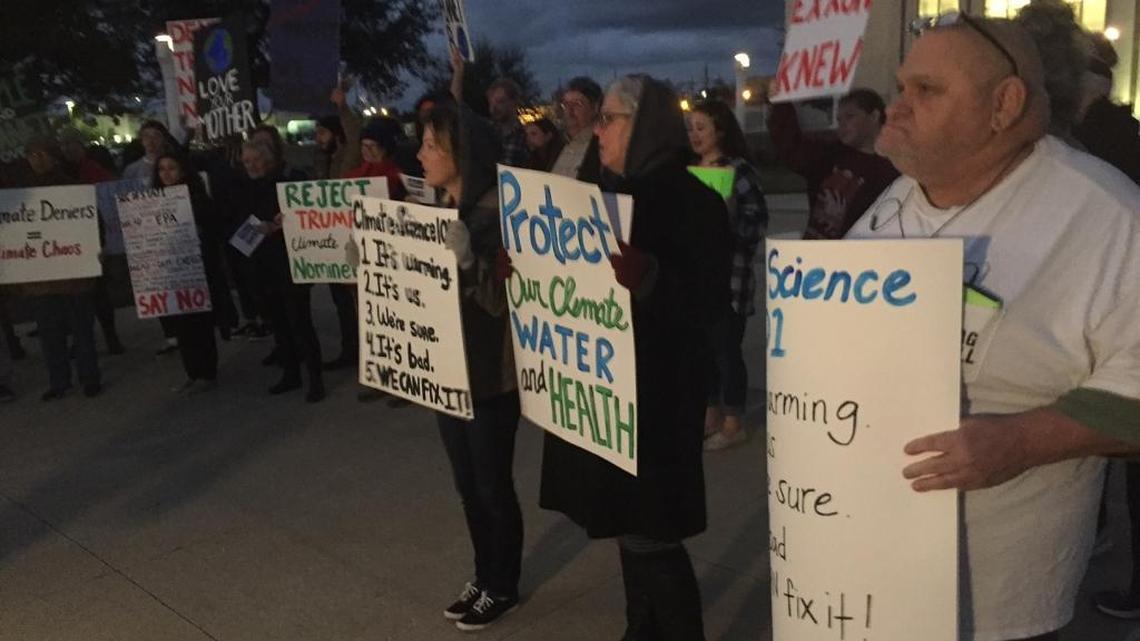 Roger Mills, right, and dozens of activists rally against climate change deniers in government outside the Gulfport federal courthouse on Monday, Jan. 9, 2017.