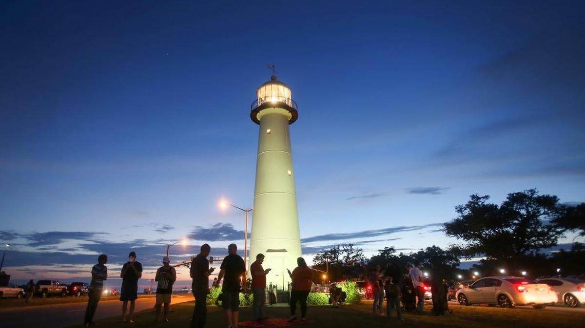 A crowd gathers at the Biloxi Lighthouse on Friday night, July 16, 2016, to play Pokemon Go. The lighthouse has become a popular spot on the Coast for Pokemon players.