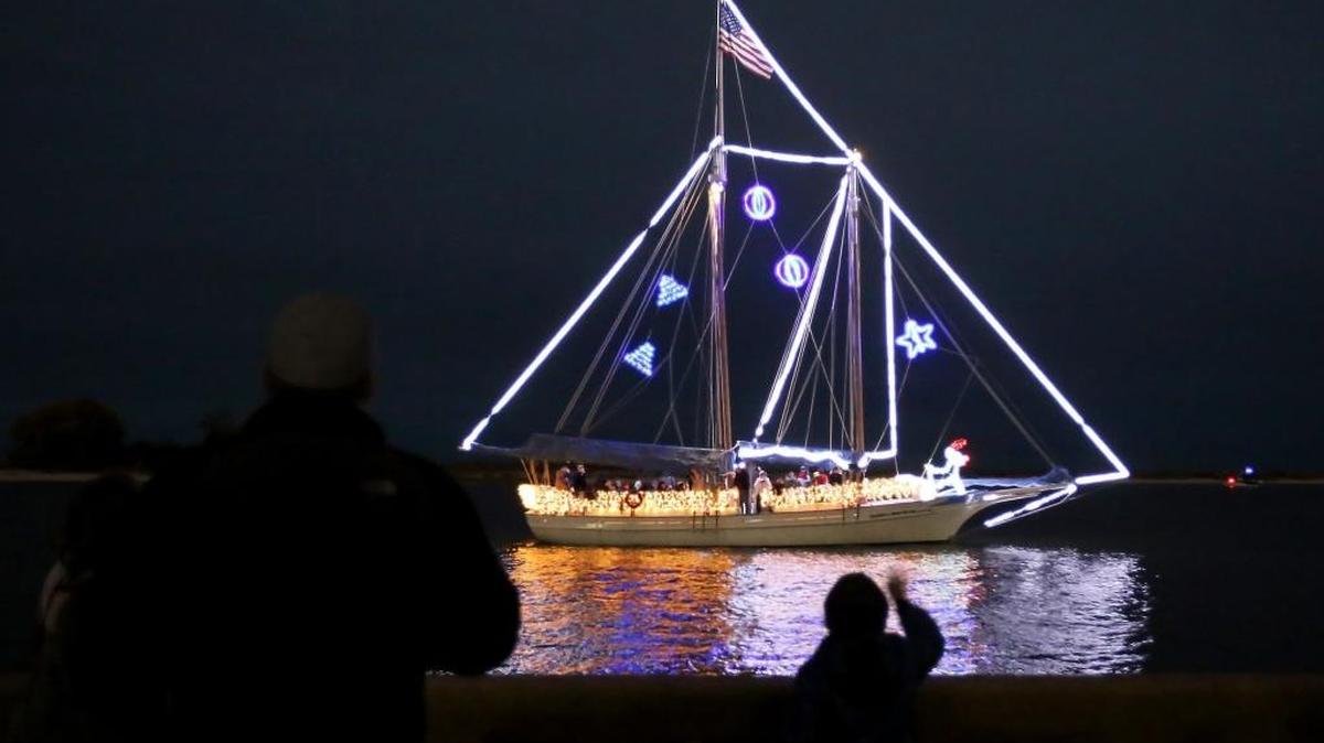 Spectators wave at the Glenn Swetman as it passes the Small Craft Harbor during the 31st Christmas on the Water Boat Parade in Biloxi, Saturday, Dec. 3, 2016.