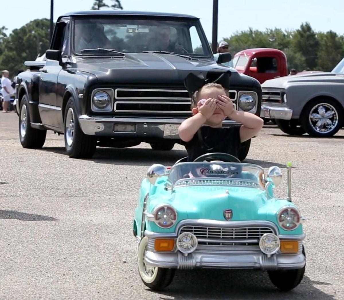 Murtie Marie Parker, 2, of Gulfport rides blind as her father, Justin, operates her remote-control classic car at Hardy Court in Gulfport on the first day of Cruisin' The Coast on Sunday, Oct. 2, 2016.
