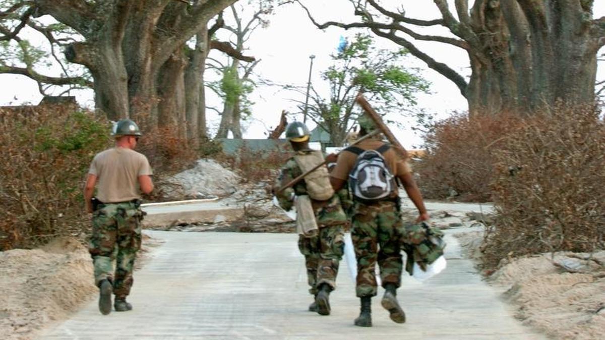 A group of Seabees walk under the Oak trees at War Memorial Park in Pass Christian, where they are encamped while helping clean up after Hurricane Katrina in 2005. The Seabees from the base in Gulfport are waiting to hear if they will be sent to Texas to help with the recovery from Hurricane Harvey.