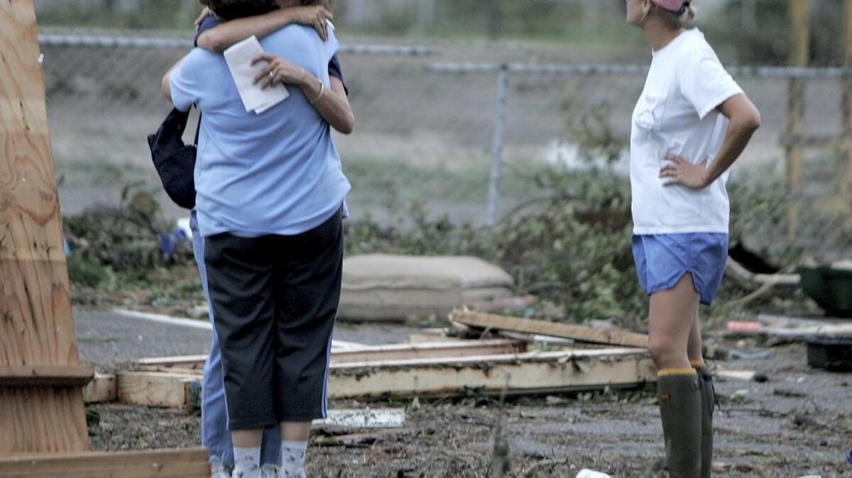 A neighbor hugs Sun Herald reporter Anita Lee, holding the notebook, on August 29, 2005. Lee was out reporting when Katrina’s winds died and had just discovered that her home was destroyed.