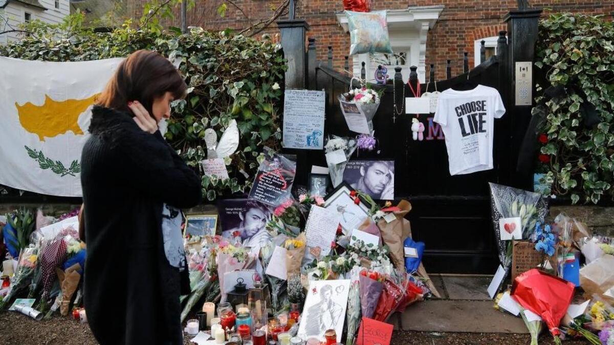 A woman mourns outside the home of British musician George Michael in London on Tuesday. Michael died on Christmas Day. He was 53.