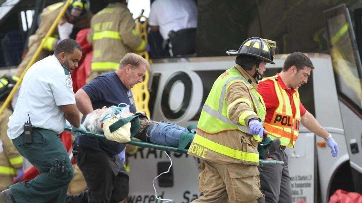 Rescue personnel carry an injured passenger from a charter bus that was hit by a CSX train at the Main Street crossing in Biloxi on Tuesday, March 7, 2017.