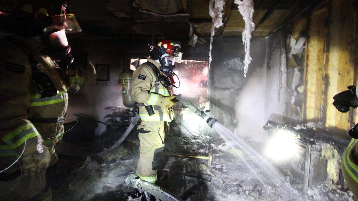 Firefighters from Lizana Fire, CRTC (Airport Fire) and the Harrison County Fire Service go through a house damaged by a fire Monday night. A smoke alarm alerted the homeowner, who was able to get out before the fire blocked her exit.