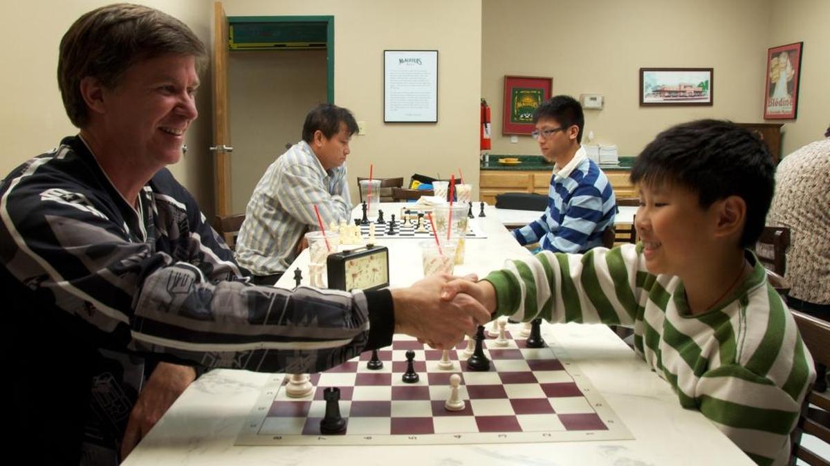 David Jenkins, left, and Esmond Tsang shake after a friendly game of chess. Chess lessons with John Hoch will be held at the Pascagoula Public Library from 10 a.m. to noon Monday through Friday.