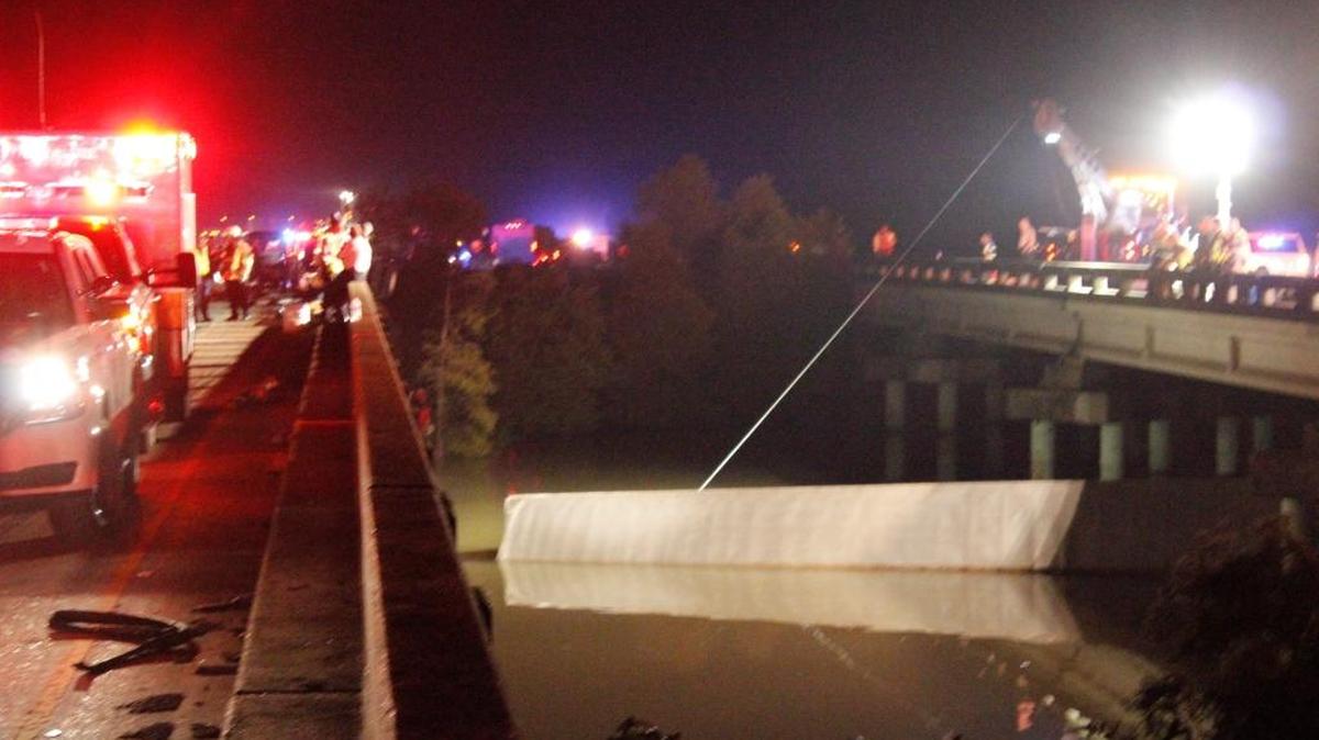 Authorities attempt to remove an 18-wheeler that plunged into the Pearl River following a hit-and-run Tuesday night. Rescue divers found the driver dead in the cab of the truck early Wednesday. Nov. 4, 2015.