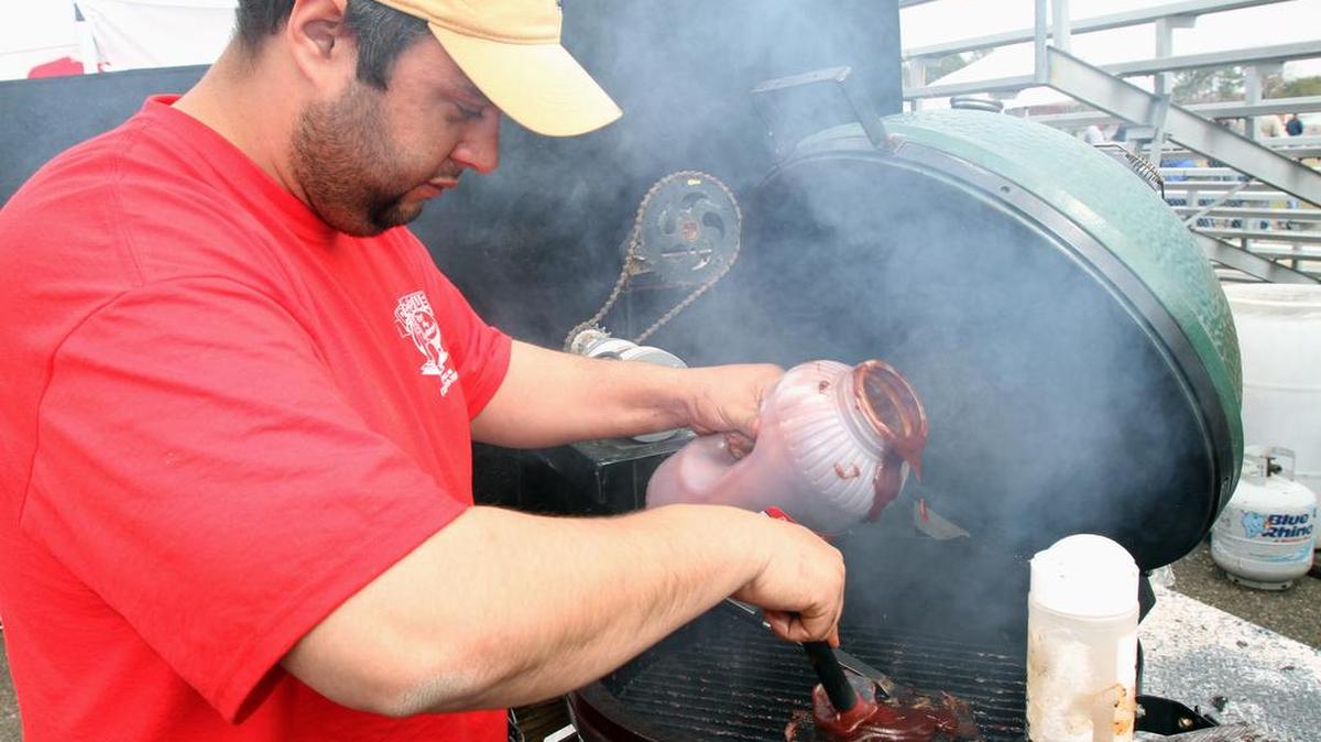Jason Ruiz puts barbecue sauce on ribs he’s cooking during D’Iberville’s fourth annual BBQ Throwdown. ‘Barbecue with Benefits: A Guide to Healthier Grilling and Smoking’ will be featured during Jim Matthews’ grilling seminar at the Orange Grove Public Library from 1 to 3 p.m. Saturday.