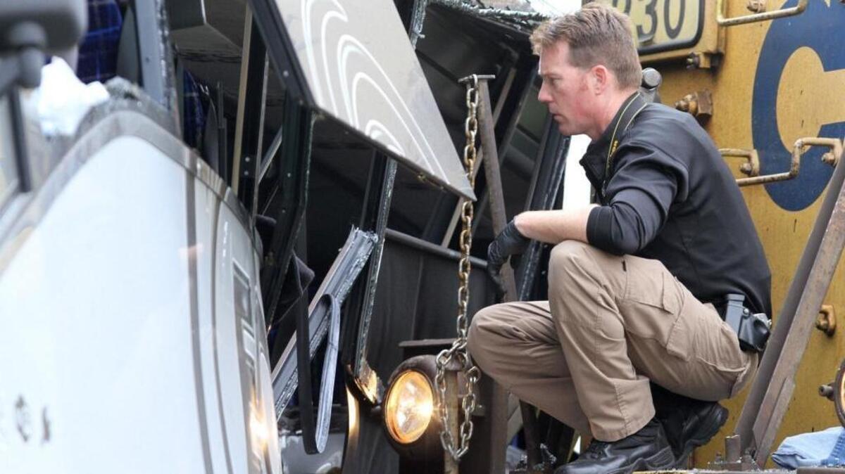 An unidentified man watches as rescue personnel work to remove passengers from a charter bus that was hit by a CSX train at the Main Street crossing in Biloxi on Tuesday, March 7, 2017.