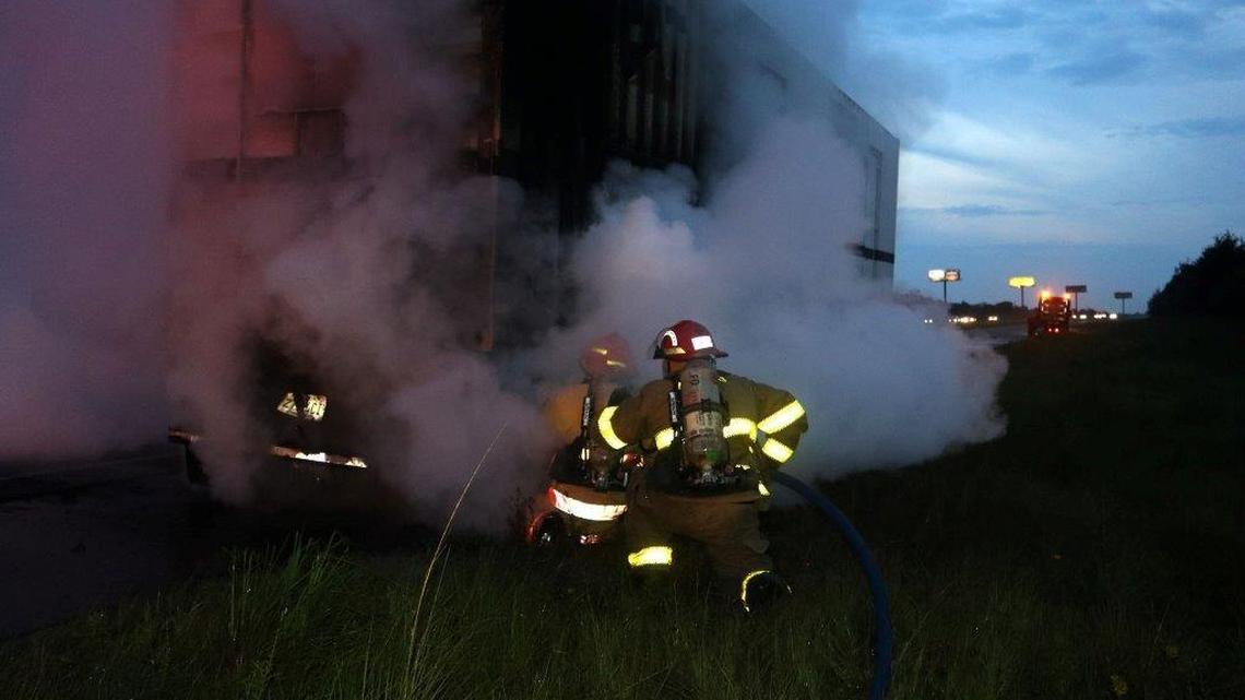 Firefighters work to put out a blaze on a burning truck that temporarily shut down westbound lanes of Interstate 10 near Pass Christian on Thursday night.