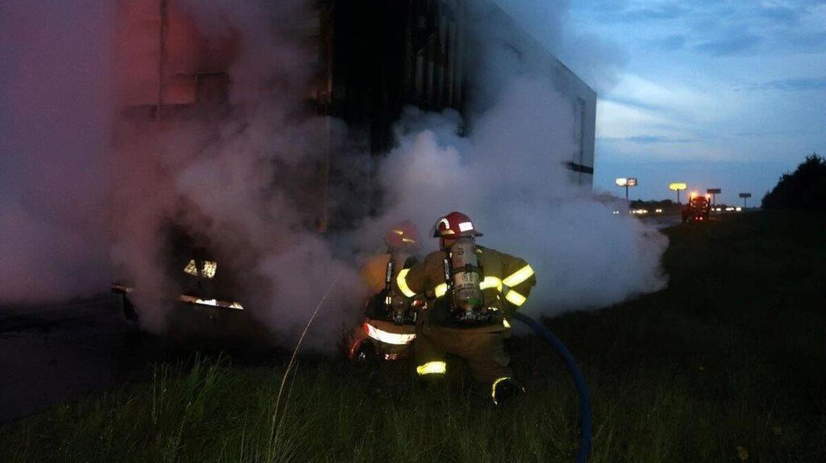 Firefighters work to put out a blaze on a burning truck that temporarily shut down westbound lanes of Interstate 10 near Pass Christian on Thursday night.