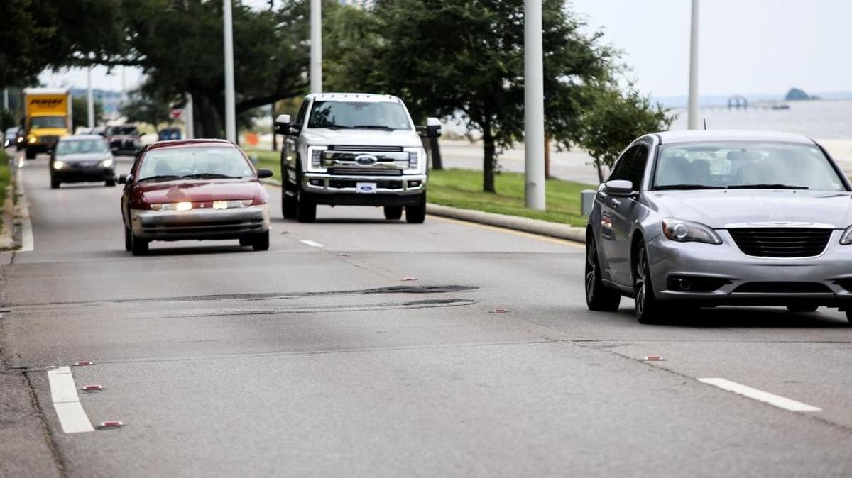 Westbound traffic flows past a section of potholes on U.S. 90 near Seashore Oaks.