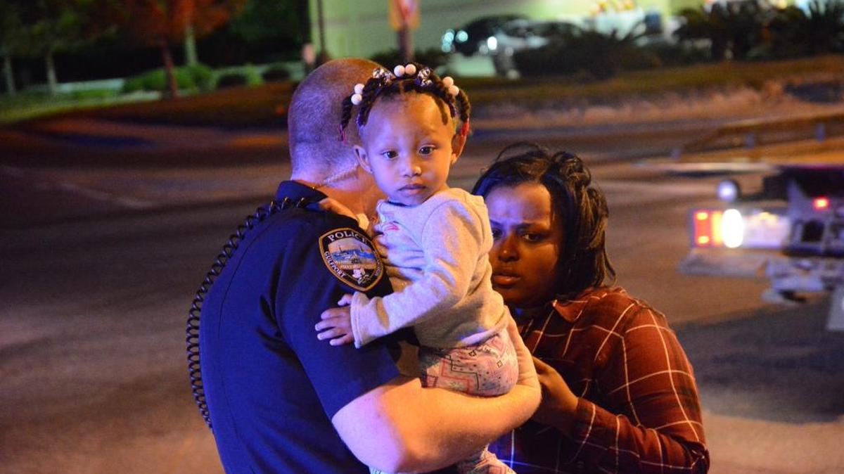 Gulfport police officer Andrew McNair held a 13-month-old baby on his shoulder after a two-vehicle accident about 7 p.m. Saturday.