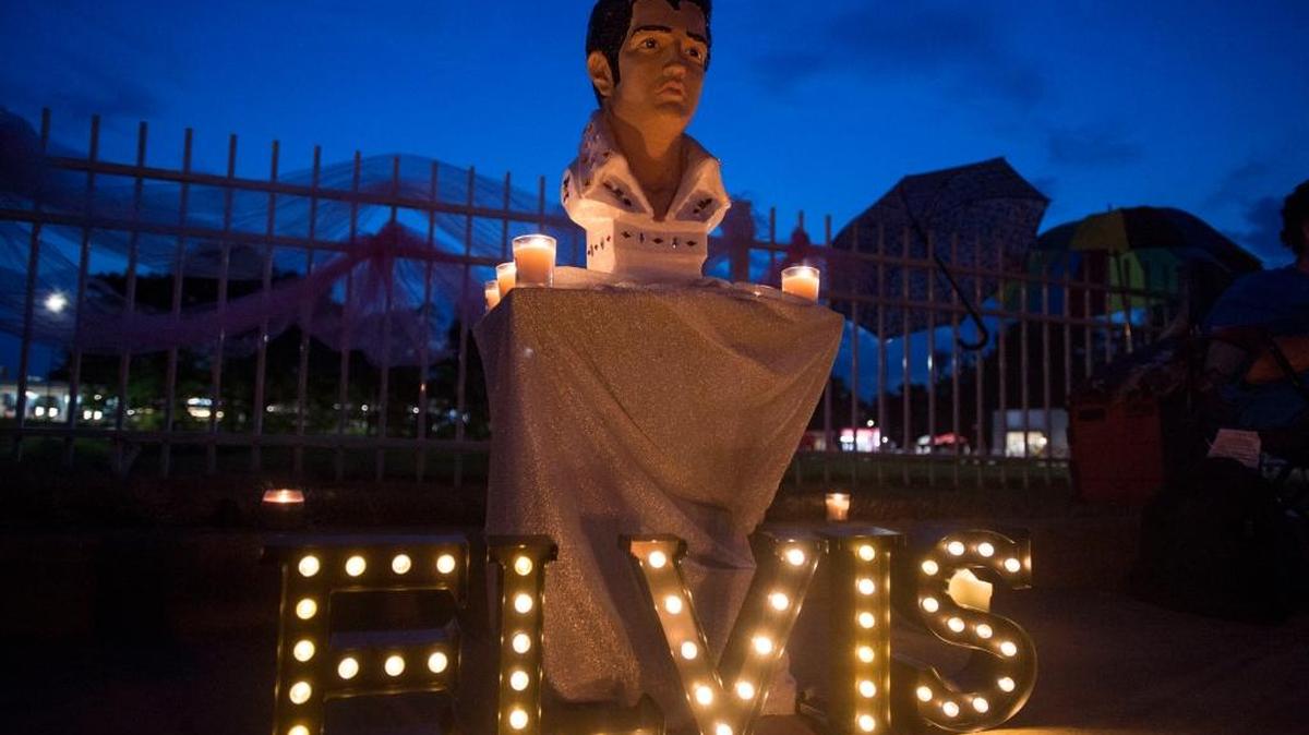 A street memorial is lit during a candlelight vigil for Elvis Presley in front of Graceland, Presley's Memphis home, on Tuesday, Aug. 15, 2017, in Memphis, Tenn. Fans from around the world are at Graceland for the 40th anniversary of his death. Presley died Aug. 16, 1977.