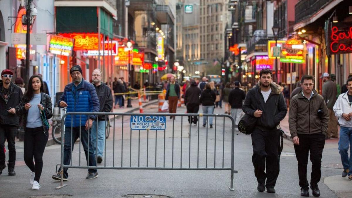 Pedestrians walk around an NOPD barricade on Bourbon Street in New Orleans on Jan. 9. Mayor Mitch Landrieu announced a massive crime-fighting plan for the city Monday, which includes a new rule that requires bars to close doors and keep patrons inside after 3 a.m.