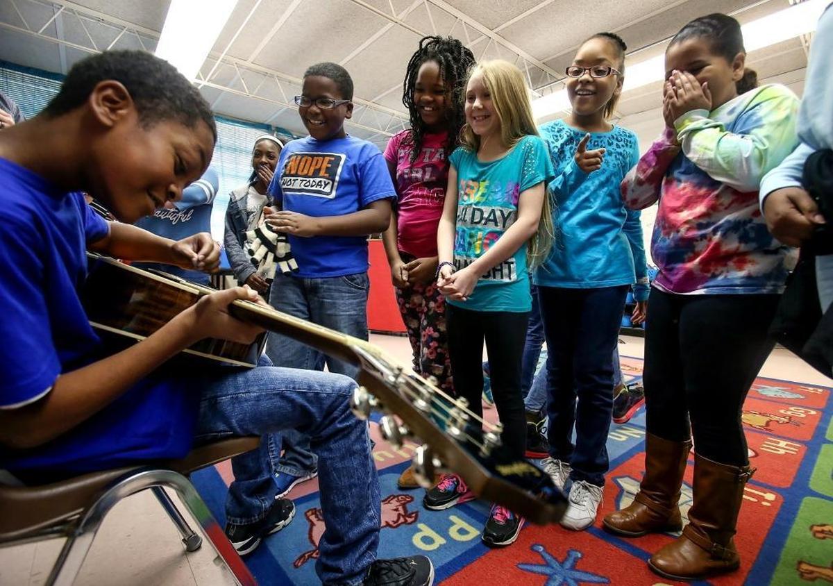 Pass Road Elementary school singers gather around as Chance Gaines, 10, tries his hand playing Sun Herald reporter Jeff Clark’s guitar during a visit on Thursday, Feb. 16, 2017. The singers would be performing with Foreigner that Saturday. Photographer’s comments: I like all of the kids’ different reactions as Chance hams it up while strumming on the guitar.