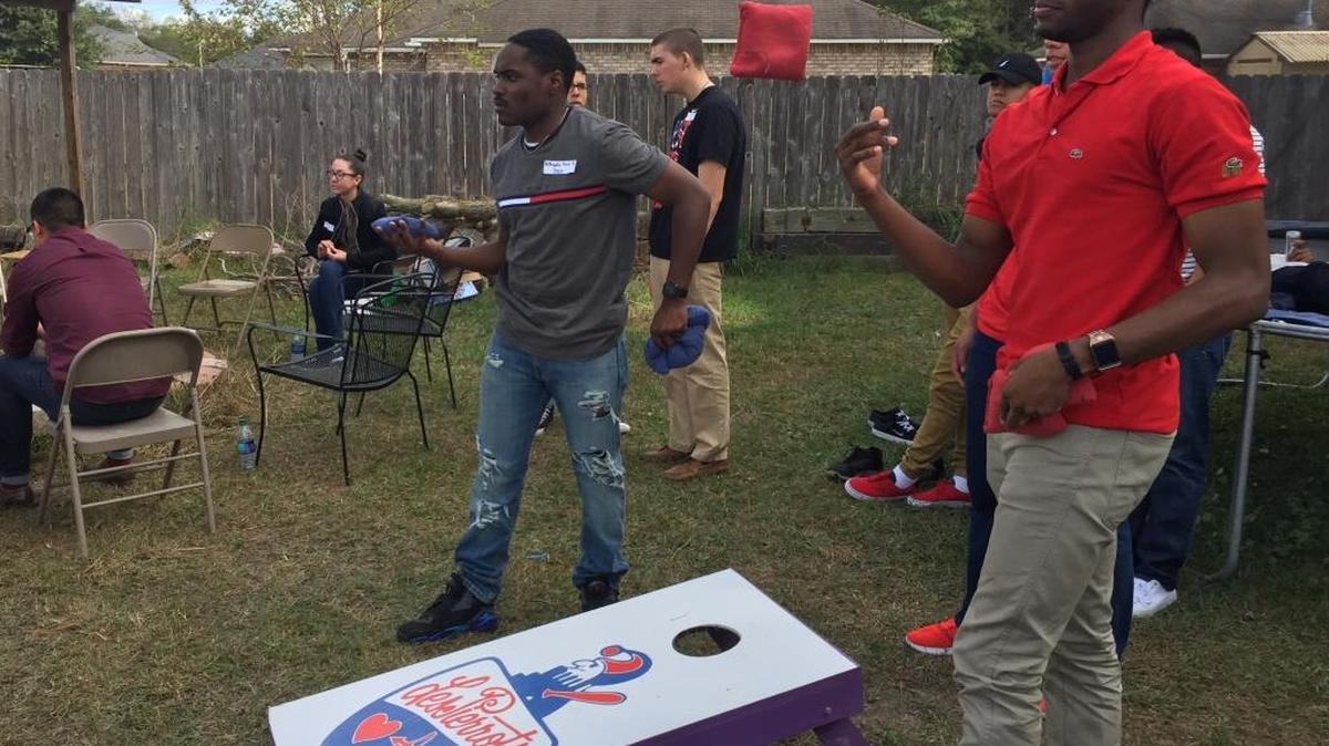 Juwan Dennis of Tampa, Fla., and Brandon Boyd of Birmingham, Ala., play corn hole in Bobby Walker’s backyard Thursday. Walker invited 31 airmen from Keesler Air Force Base in Biloxi to his Ocean Springs home for Thanksgiving dinner.