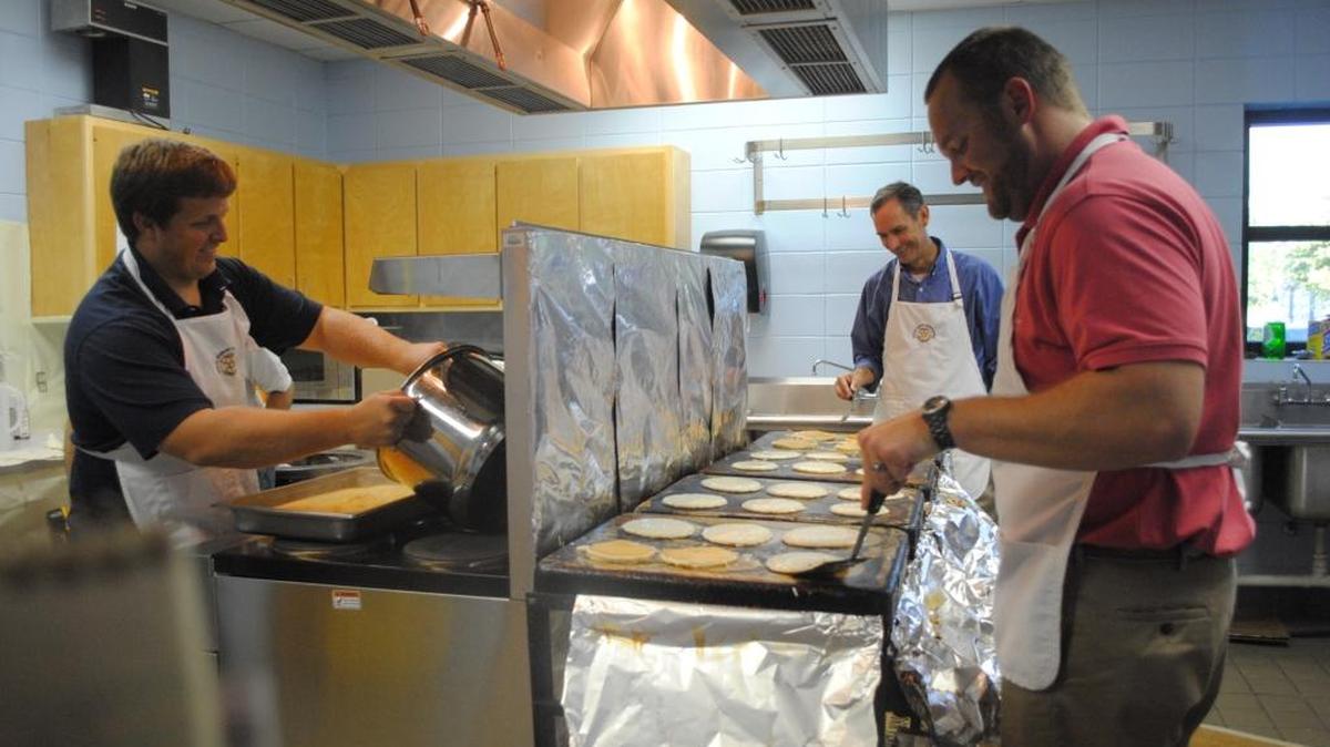 Rotary Club members Justin Struble of Moss Point, left, and Heath Thompson and Michael Johns, both of Ocean Springs, flip pancakes and prepare sausage and grits for the Ocean Springs Rotary Club’s annual pancake dinner at the Ocean Springs Civic Center. This year as part of 100 Days of Service, the Ocean Springs Rotary plans to serve pancakes at the Ronald McDonald House in Mobile, along with helping non-profit groups throughout the community.