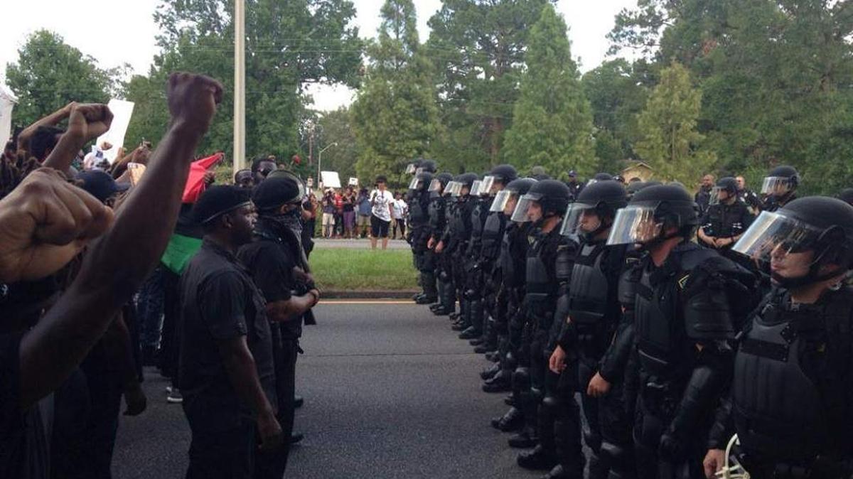 Louisiana State Police in riot gear confront armed Black Panther protesters outside of Baton Rouge police headquarters on Saturday, July 9.