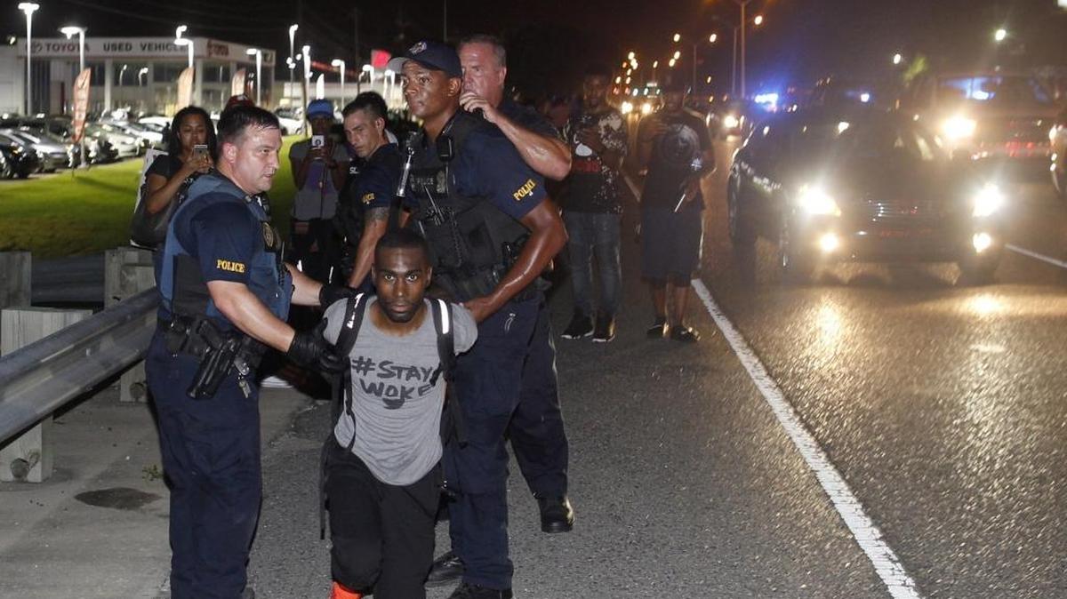 Police arrest activist DeRay McKesson during a protest along Airline Highway, a major road that passes in front of the Baton Rouge Police Department headquarters Saturday, July 9, 2016, in Baton Rouge, La. Protesters angry over the fatal shooting of Alton Sterling by two white Baton Rouge police officers rallied Saturday at the convenience store where he was shot, in front of the city's police department and at the state Capitol for another day of demonstrations.