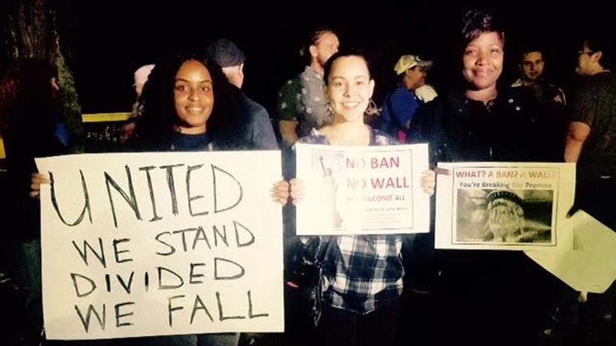 Jocelyn Bays, left, Candice Flowers and Tanika Williams were among the 130 or so people protesting the temporary immigration ban Tuesday evening on the University of Southern Mississippi’s Long Beach campus.