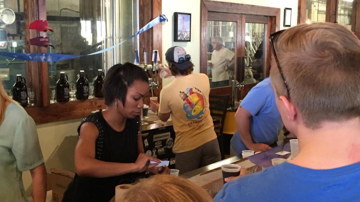 A bartender punches a beer card at Chandeleur Brewing Company in Gulfport. As it stands, craft breweries are allowed to conduct tours that include tastings but not sell their products on site.