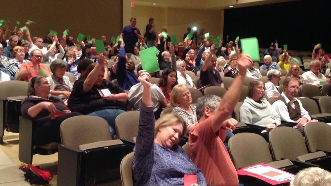 Green cards go up in favor of a speaker who took aim at U.S. Rep. Steven Palazzo’s stand on LGBTQ rights at a town hall meeting Feb. 24 in Long Beach.