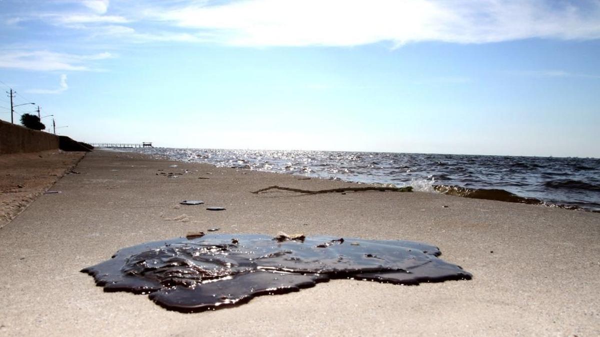 Oil the size of a football sits on the beach in Waveland in 2010. Oil continued to wash ashore in Harrison and Hancock counties, causing some beaches to be closed.