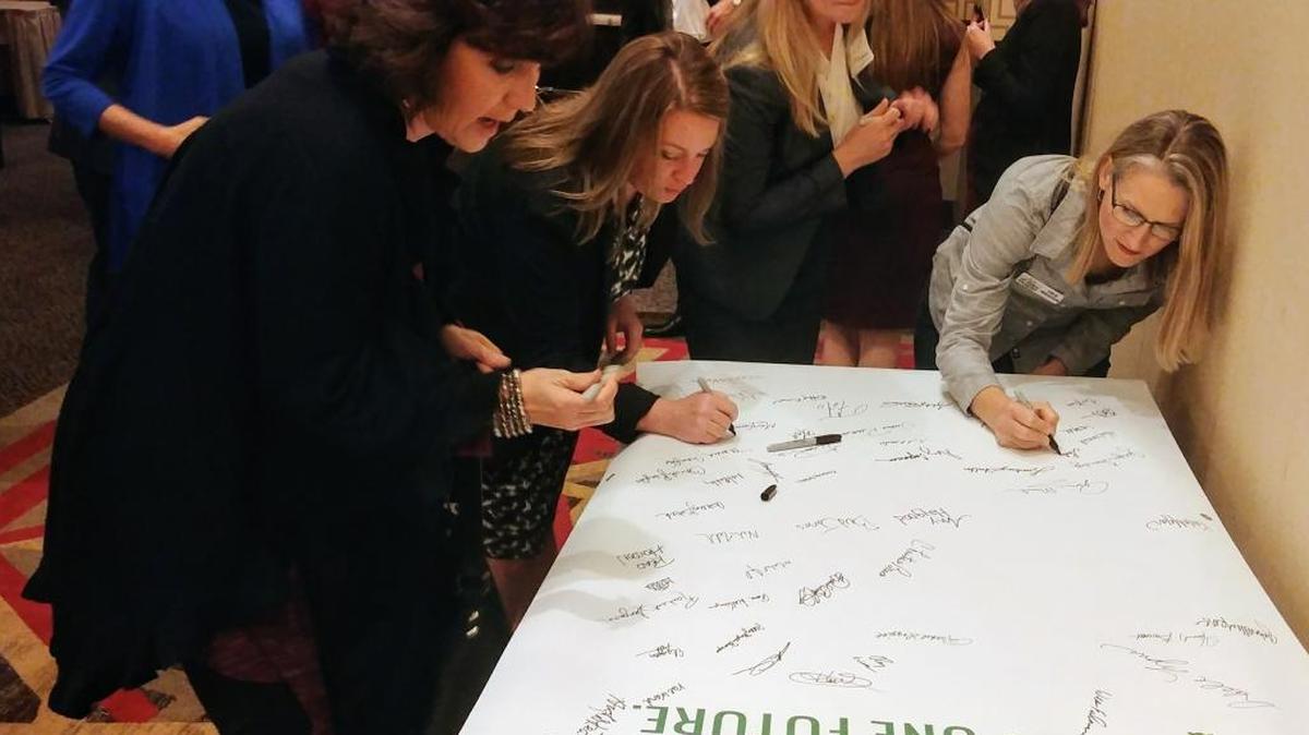 People from the audience at the Mississippi Gulf Coast Chamber of Commerce Pre-Legislative Briefing sign a banner that will head to Jackson for the annual Legislative Reception.