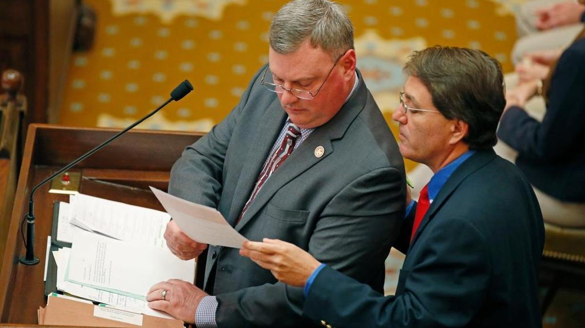 House Banking and Financial Services chairman Hank Zuber III, R-Ocean Springs, right, hands his committee member, Rep. Jeff Hale, R-Nesbit, a bill explanation at the speaker's well at the Capitol in Jackson, Miss., Wednesday, March 23, 2016. Lawmakers in both chambers were rushing to meet deadlines.