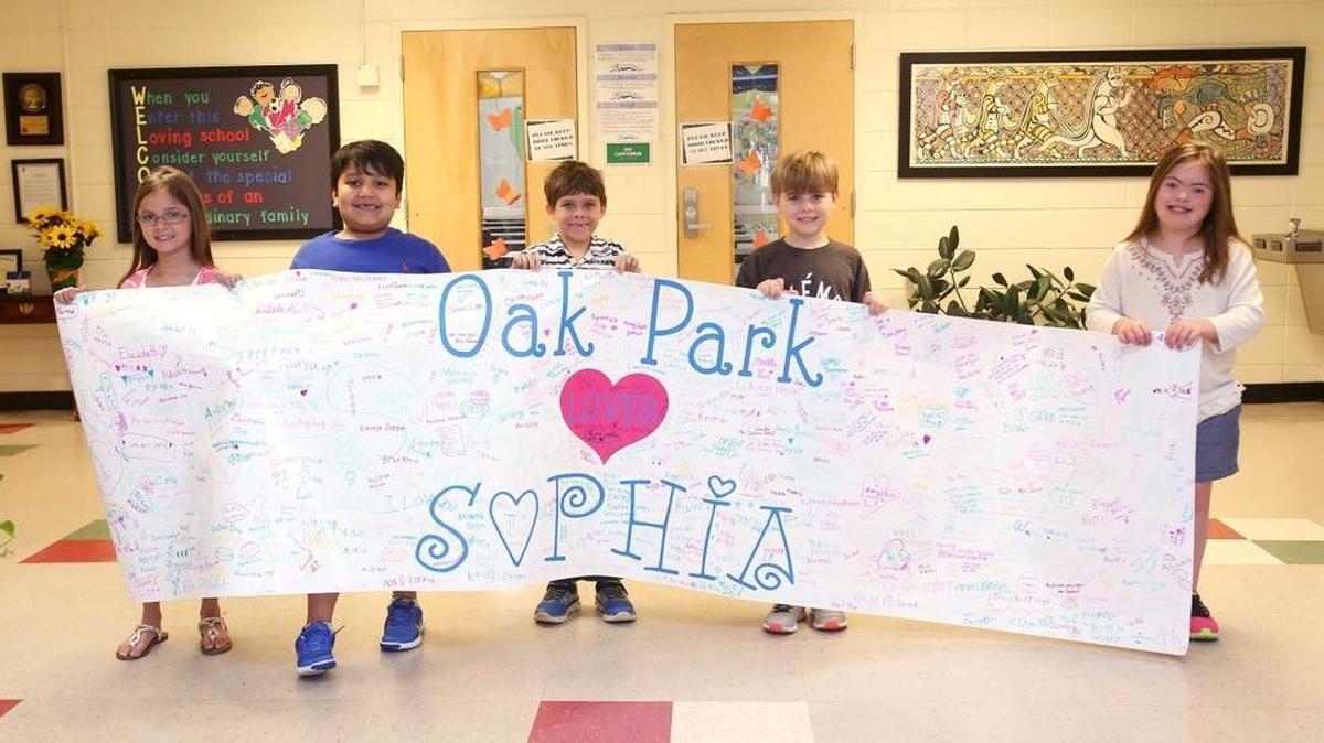 Oak Park Elementary School students hold a banner for Sophia Myers signed by students at the Ocean Springs school in April. Myers was a first-grader at the school when she was diagnosed in February with DIPG. The school and community have rallied behind the 7-year-old, offering support and holding numerous fundraisers for medical bills.