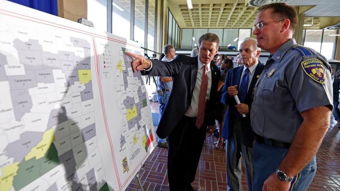 Then-Mississippi Bureau of Narcotics director Marshall Fisher, left, explains how the charts list reported drug overdose cases from each county, after a 2013 news conference on a new effort to educe prescription-drug abuse. The state Department of Public Safety and MBN set up 10 safe boxes at driver's license offices around Mississippi providing people a place they can drop off unneeded prescription drugs in the secure boxes, no questions asked.