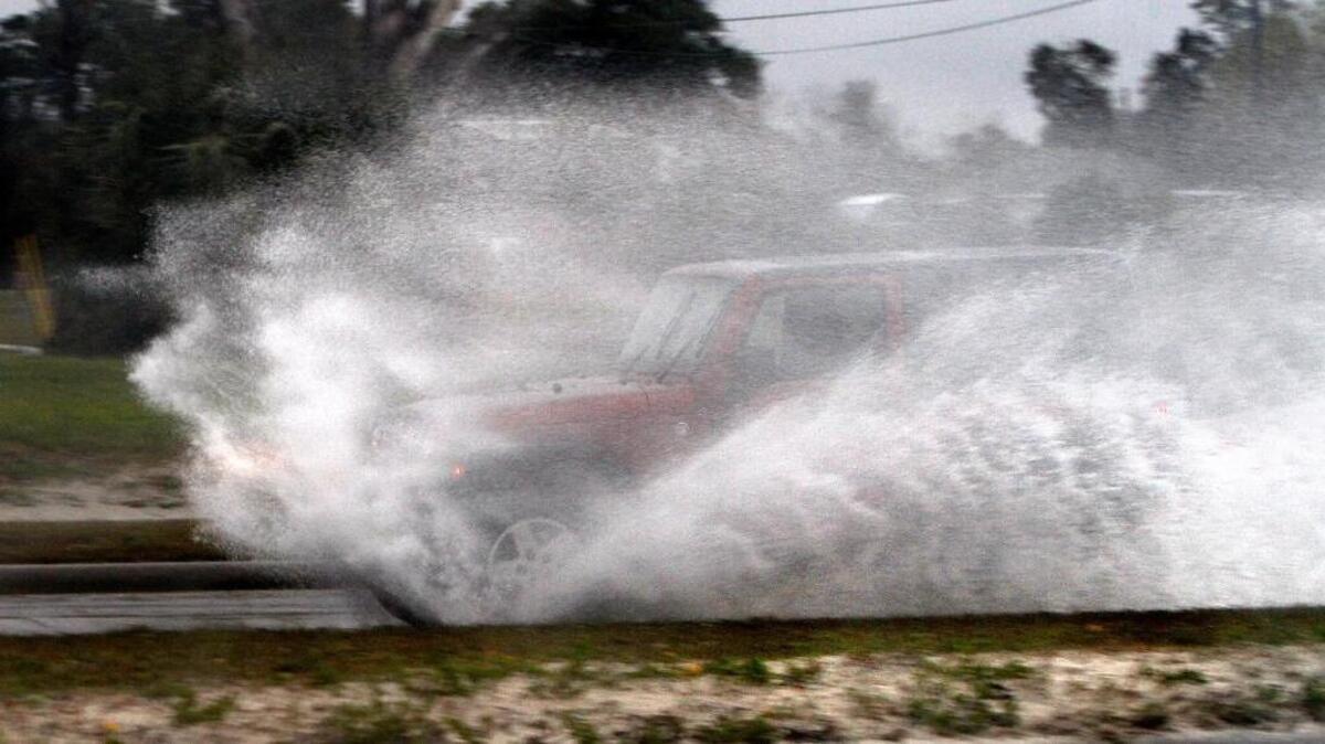 A motorist blasts through a puddle of water on U. S. 90 in Gulfport, Friday, Jan. 6, 2017. Cold temperatures could drop below freezing causing puddles to freeze. Motorists should be on the lookout for icy roads and bridges Saturday.