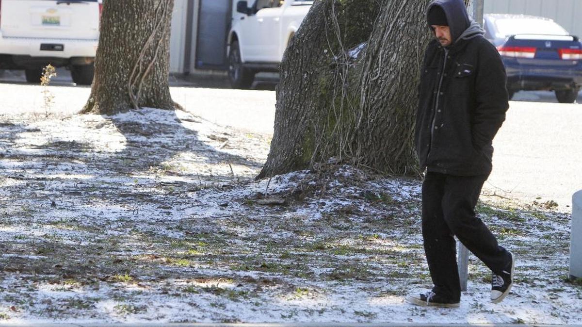 Josh Johnson of D'Iberville walks home on Wednesday, Jan. 17, 2018, after frozen rain fell across South Mississippi overnight.