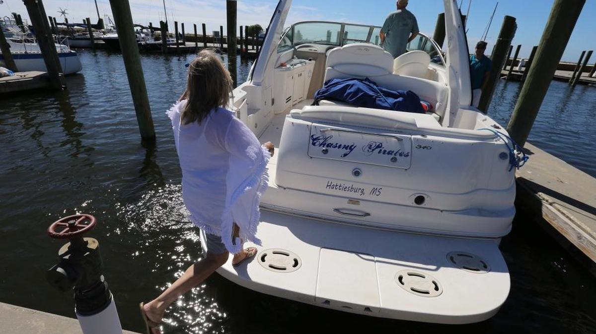 Brenda Kent of Hattiesburg jumps on her boat as she and her husband leave the Biloxi Small Craft Harbor on Friday to take the boat up river in advance of Tropical Storm Nate.