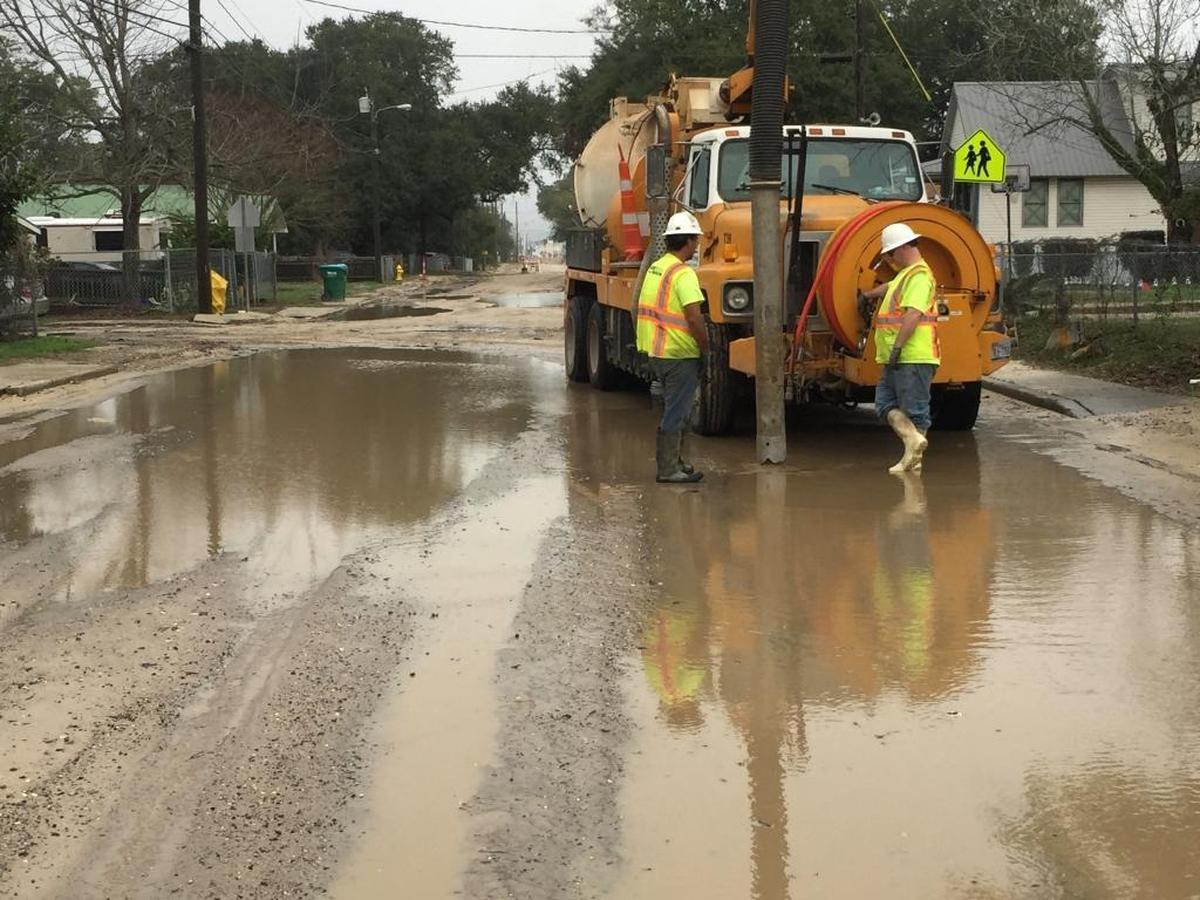 Employees of Oscar Renda contracting pump water from a puddle on Lee Street in East Biloxi on Tuesday.