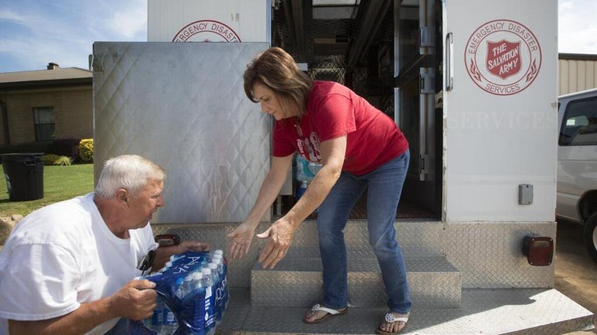 Harlan Jones, left, and Sann Terry, both with the Texarkana Salvation Army, load water into a response vehicle Aug. 25 at their warehouse in Texarkana, Arkansas, to help people in Texas after Hurricane Harvey.