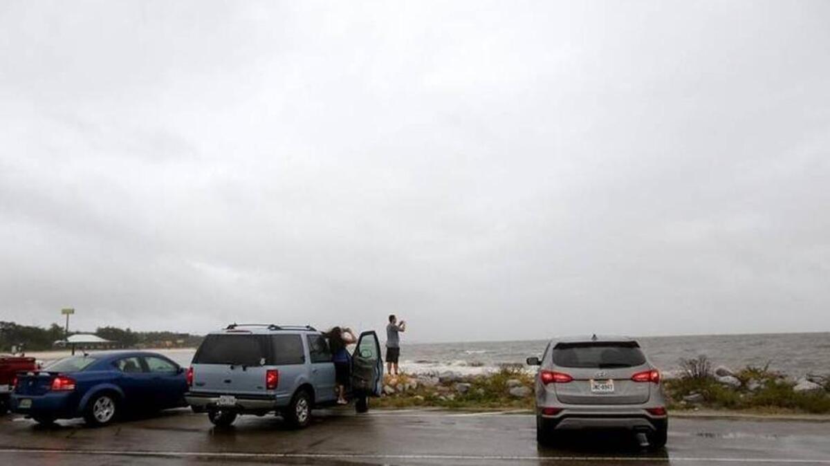 Spectators watch as the waves intensify on the Gulfport beach as Hurricane Nate approaches landfall on Saturday, October 7, 2017.