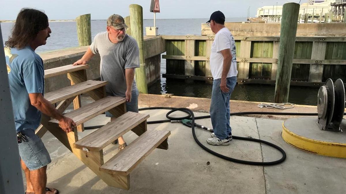 Glen Davis, left, Zelenograd Jermyn and Pat Kuluz, all of Biloxi, prepare for hurricane Nate at Biloxi Harbor Fuel and Bait at the Biloxi small craft harbor on Saturday.