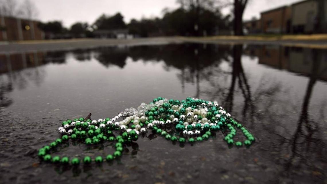 Beads lay in a puddle of water in Gulfport in this file photo, reflecting how people in South Mississippi feel this year as more 2021 Mardi Gras parades are canceled because of the coronavirus.