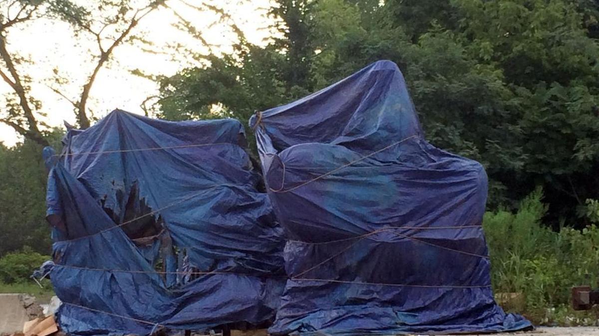 A day after four Confederate monuments were removed from public spaces in Baltimore, they sit tarped in a city-owned lot Thursday awaiting their final destination.