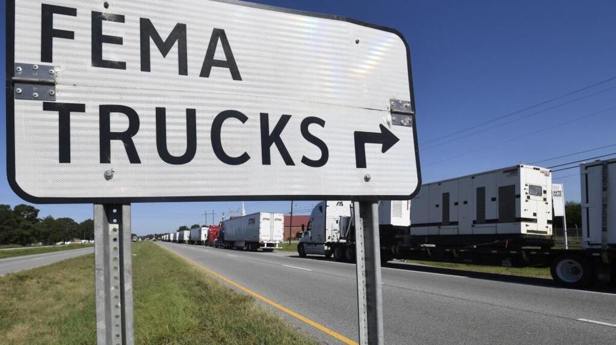 Trucks carrying FEMA supplies line up to enter Maxwell Air Force Base in Montgomery, Ala., a staging area for hurricane relief.