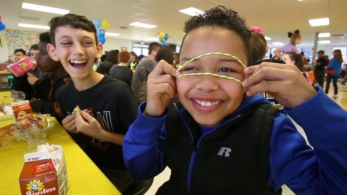 Deion Williams clowns around with friends at the yellow bracelet table at D'Iberville Middle School during No One Eats Alone day. Students are given different color bracelets and eat at the table with kids wearing the same color.