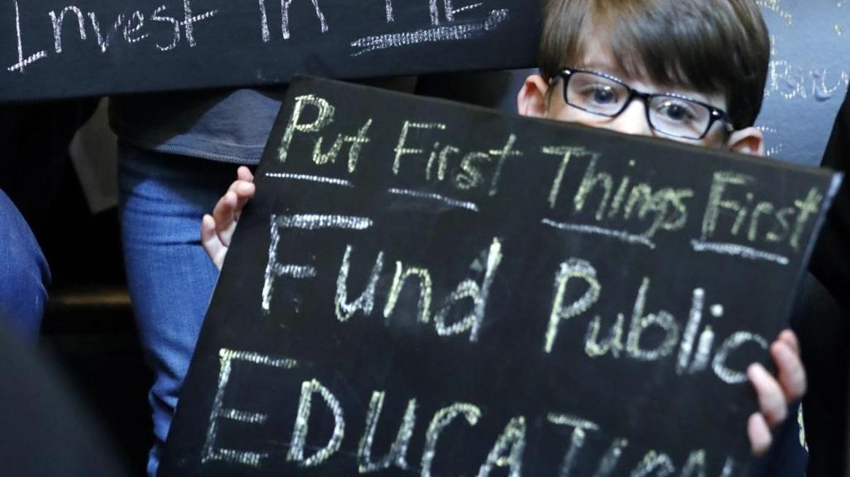 Students holds up rally signs, joining several hundred parents, educators, education activists and a handful of legislators in an education rally at the Capitol in Jackson on March 16.