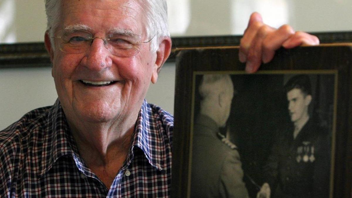 Jerry O’Keefe of Biloxi holds a photograph in June 2007 of himself receiving medals for his exploits as a Marine pilot during World War II.