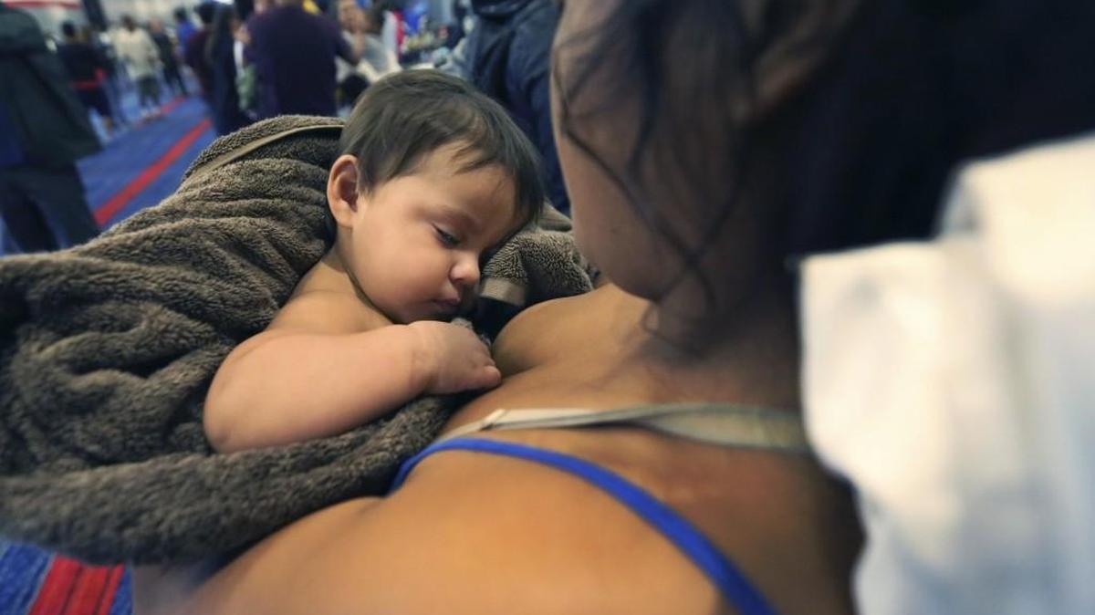 Faith Hernandez is held by her mother Alexis Hernandez as they make their way into a crowded George R. Brown Convention Center after evacuation from the floodwaters from Tropical Storm Harvey in Houston, Texas, on Tuesday.